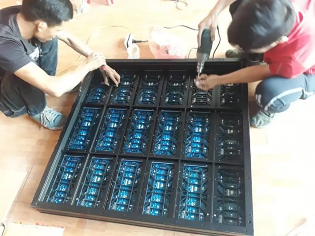 Kỹ thuật viên đang lắp đặt cabinet LED trong nhà